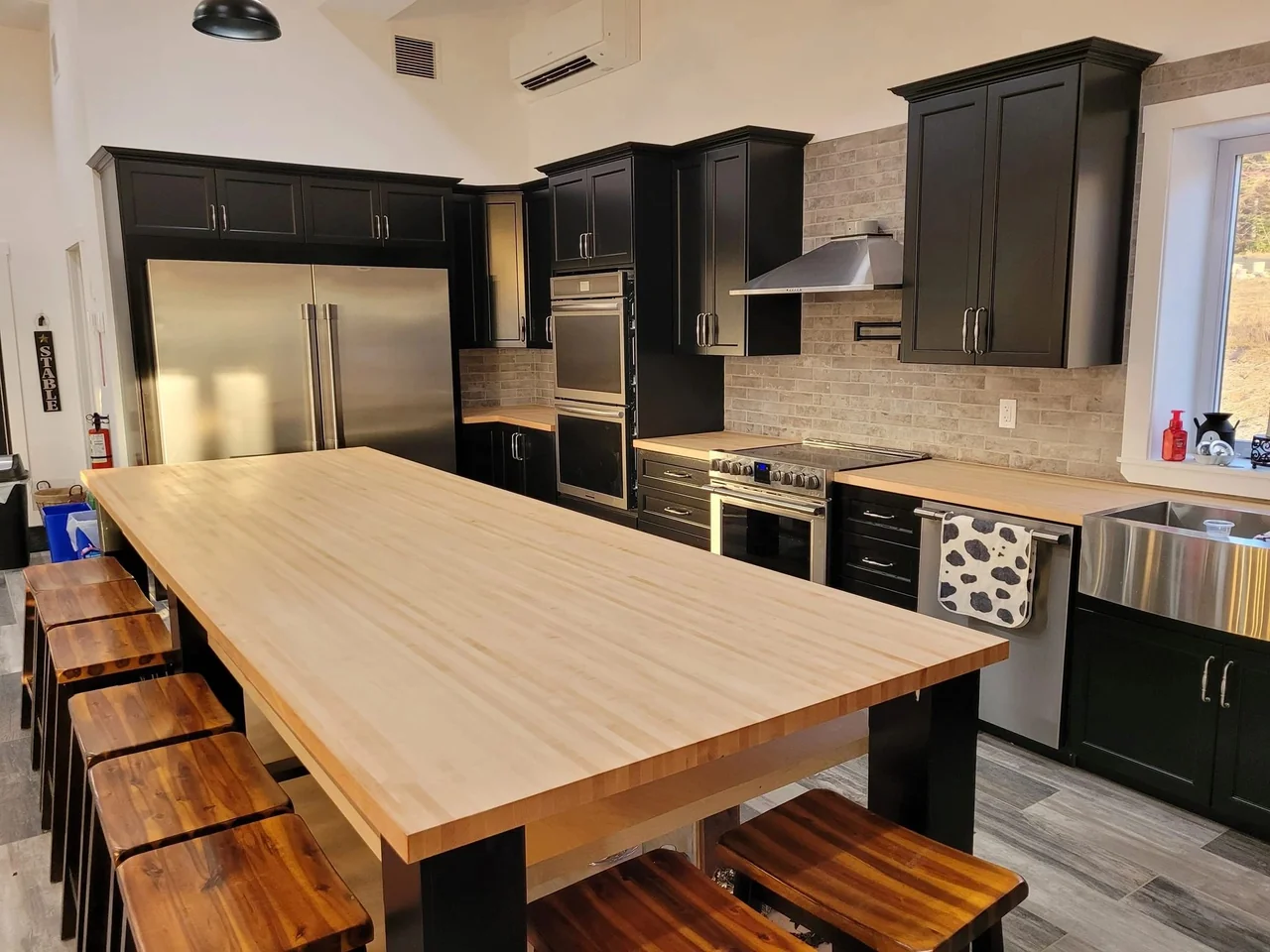 Dark cabinetry, open shelves and a wood island